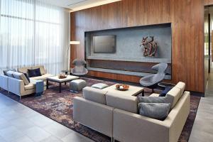 uma sala de estar com um sofá e uma televisão em AC Hotel by Marriott San Jose Santa Clara em Santa Clara