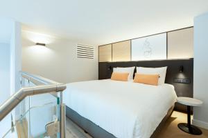 a bedroom with a large white bed and a staircase at Residence Inn by Marriott The Hague in The Hague