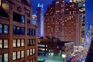 TownePlace Suites by Marriott New York Manhattan/Times Square في نيويورك: اطلالة على مدينة بالليل بمباني طويلة