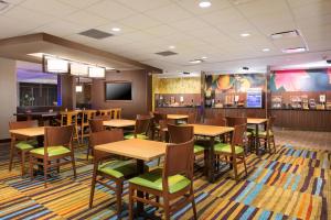 um restaurante com mesas e cadeiras de madeira e um bar em Fairfield Inn & Suites by Marriott Sacramento Folsom em Folsom