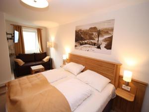 a bedroom with a large bed and a couch at Alpensteinbock Mauterndorf II in Mauterndorf
