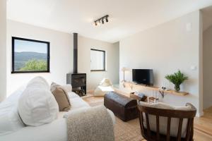 a living room with a white couch and a fireplace at Casa da Zanjas in Seia