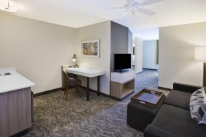 a living room with a couch and a desk and a tv at SpringHill Suites Minneapolis-St. Paul Airport/Eagan in Eagan