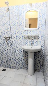 a bathroom with a sink and a mirror at Le Poulagou in Saint-Louis