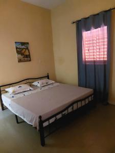 a bed in a room with a window and a bedspread at Le Poulagou in Saint-Louis