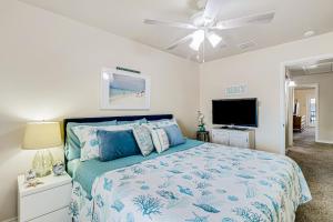 a bedroom with a bed and a ceiling fan at Feelin' Beachy in Padre Island