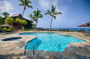a swimming pool with a view of the ocean at Kanaloa At Kona 701 in Kailua-Kona