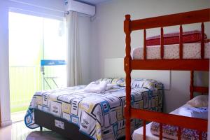 1 dormitorio con 2 literas y ventana en Recanto das tartarugas Flats, en Penha