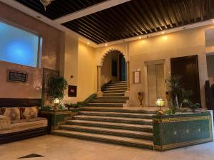 eine Lobby mit Treppe in einem Gebäude mit Sofa in der Unterkunft Hotel Majorelle in Marrakesch
