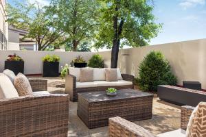 a patio with wicker furniture and a fence at Sheraton Suites Chicago O'Hare in Rosemont