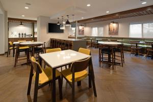 um restaurante com mesas e cadeiras e um bar em Fairfield by Marriott Inn & Suites Seattle Sea-Tac Airport em SeaTac