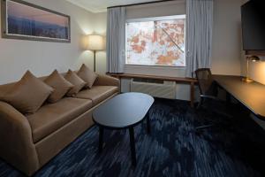 uma sala de estar com um sofá, uma mesa e uma janela em Fairfield by Marriott Inn & Suites Seattle Sea-Tac Airport em SeaTac