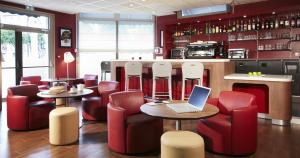 a restaurant with red chairs and a laptop on a table at Campanile Paris Ouest - Chaville in Chaville
