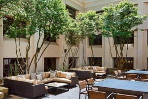 サンフランシスコにあるサンフランシスコ マリオット マーキーズ ユニオン スクエアのソファ、テーブル、木々が備わるホテルロビー