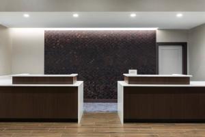 a lobby with two counters and a brick wall at Residence Inn Long Island Garden City in Garden City