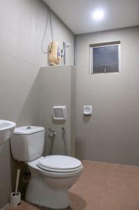 y baño con aseo y lavamanos. en Five H Family Service Apartment, en Seri Kembangan
