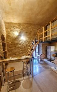 奧菲達的住宿－Chiocciola，配有桌椅和砖墙的房间