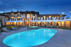 a large swimming pool in front of a building at Tota Virginia Antico Podere in Serralunga d'Alba