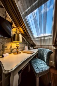a desk with two chairs and a lamp and a window at Prestige Hotel Budapest in Budapest