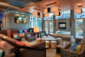 a lobby with couches and chairs and a fireplace at Aloft Vaughan Mills in Vaughan