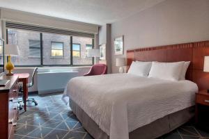 a hotel room with a large bed and a bath tub at Courtyard by Marriott New York Manhattan/ Fifth Avenue in New York