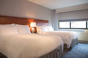 a hotel room with two beds and a window at Courtyard by Marriott New York Manhattan/ Fifth Avenue in New York