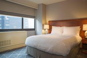 a bedroom with a large bed and a large window at Courtyard by Marriott New York Manhattan/ Fifth Avenue in New York