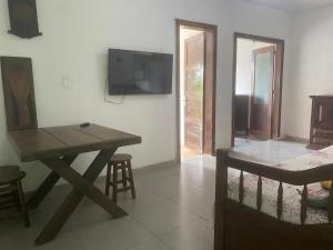 ein Wohnzimmer mit einem Holztisch und einem TV in der Unterkunft Rio Natureza apart 113 in Rio de Janeiro