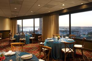 a restaurant with tables and chairs and large windows at Four Points by Sheraton San Diego Downtown Little Italy in San Diego
