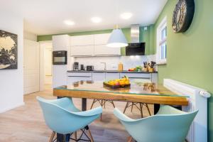 cocina con mesa de madera y sillas azules en Suite Wind & Wellen, en Zingst