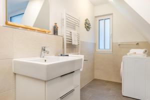 Baño blanco con lavabo y aseo en Suite Wind & Wellen, en Zingst
