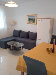 a living room with a blue couch and a table at Apartments by the sea Valun, Cres - 386 in Valun