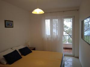 a bedroom with a large bed and a window at Apartments by the sea Valun, Cres - 386 in Valun