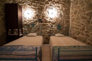 2 camas en una habitación con una pared de piedra en Casas dos Avos, en Vale de Cambra