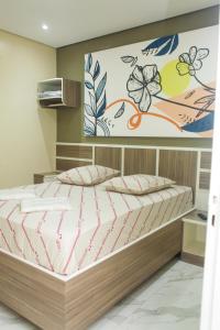 um quarto com uma cama e um quadro na parede em Hotel Tenda Obsession em São Paulo