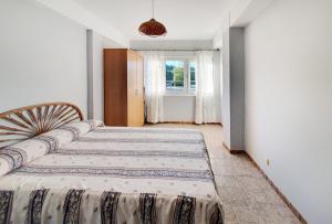 Un dormitorio con dos camas y una ventana. en La Casa de Ana en Fisterra, en Finisterre