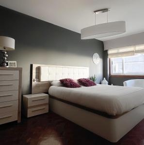 a bedroom with a large white bed and a window at APARTAMENTO TORRE DE HÉRCULES A CORUÑA con GARAJE in A Coruña