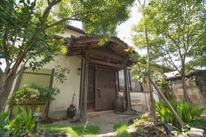 una casa con una puerta de madera y una valla en 山鹿師蔵 en Yamaga