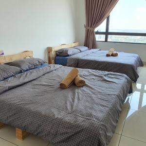 two beds with towels on them in a room at Woodsbury Homestay Butterworth in Butterworth