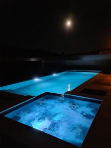 a swimming pool at night with the moon in the background at Casa do Moleiro in Mortágua