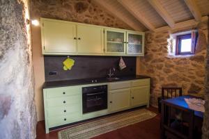 a kitchen with white cabinets and a sink at Casas dos Avos in Vale de Cambra