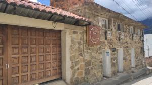 un edificio de piedra con puerta de garaje de madera en Hotel Brisas del Nevado, en Güicán