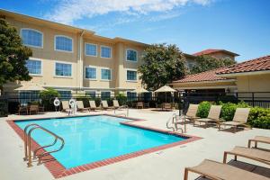 a swimming pool with chairs and a building at Residence Inn Temple in Temple