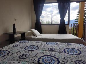 GüicánにあるHotel Brisas del Nevadoのベッドルーム1室(ベッド2台、窓付)