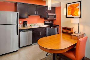 a kitchen with a wooden table and a refrigerator at Residence Inn Sacramento Cal Expo in Sacramento