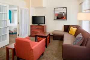 a living room with a couch and chairs and a tv at Residence Inn Sacramento Cal Expo in Sacramento