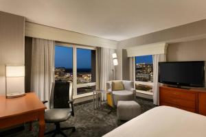 a hotel room with a bed and a desk and a television at Courtyard by Marriott Tysons McLean in Tysons Corner