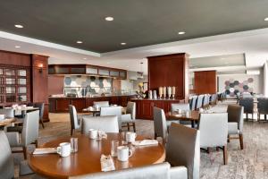 a restaurant with tables and chairs and a kitchen at Courtyard by Marriott Tysons McLean in Tysons Corner