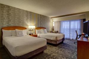 a hotel room with two beds and a television at Courtyard by Marriott Tysons McLean in Tysons Corner