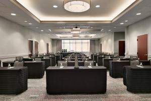 タイソンズ・コーナーにあるCourtyard by Marriott Tysons McLeanのテーブルと椅子が並ぶ広い部屋